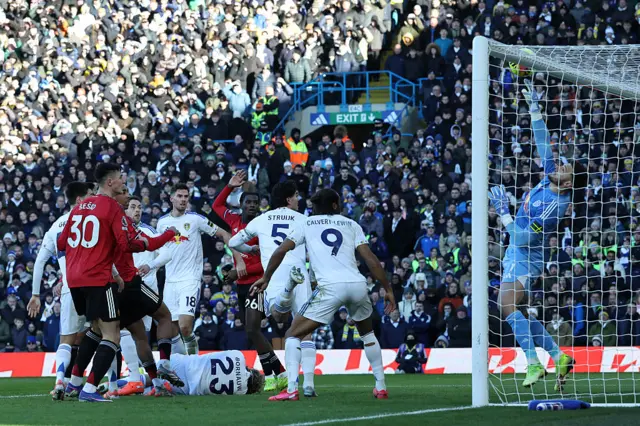 Leeds United's Brazilian goalkeeper #01 Lucas Perri (R) saves a header from Manchester United's French defender #15 Leny Yoro