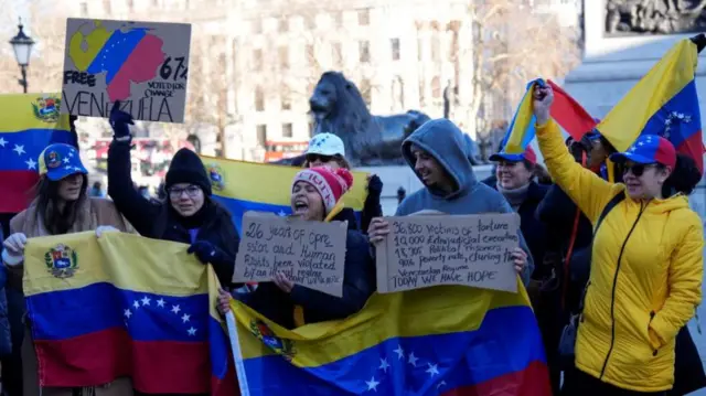 People hold placards and Venezuelan flags during a rally calling for a democratic transition in Venezuela