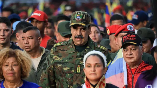 Maduro walking among a parade of people, wearing military uniform