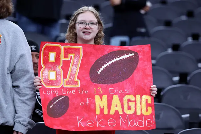 A Taylor Swift and Travis Kelce fan holds a sign during the Kansas City Chiefs' game at the Las Vegas Raiders in January 2026