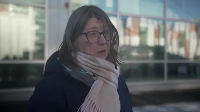 A woman wearing glasses and a scarf