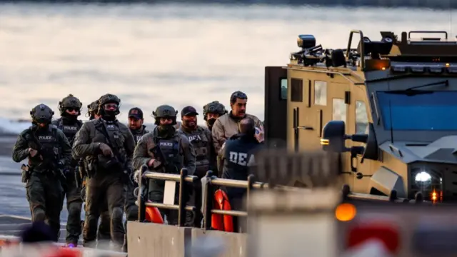 Maduro in the process of being transferred - there are many officials around him and he is approaching a large vehicle