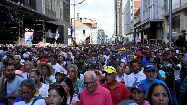 thousands of protesters standing in a city street