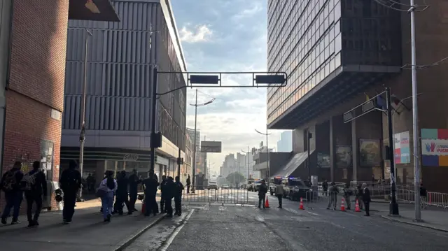 A street closed off by a fence outside the parliament building