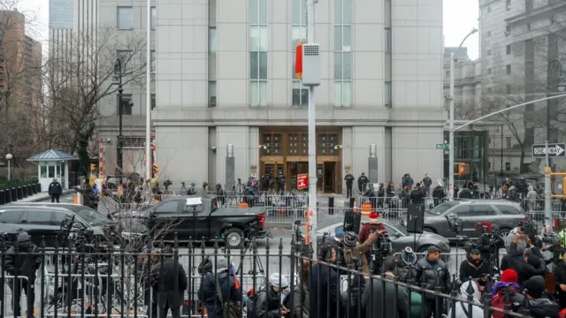 A shot of the courthouse from the other side of the road, where there are lots of different camera crews gathered behind barricades