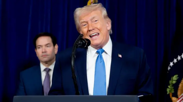 President Trump speaking into a microphone from behind a lectern
