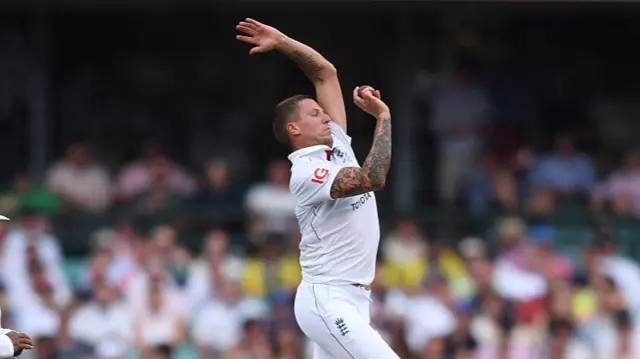 Brydon Carse bowls past umpire Ahsan Raza