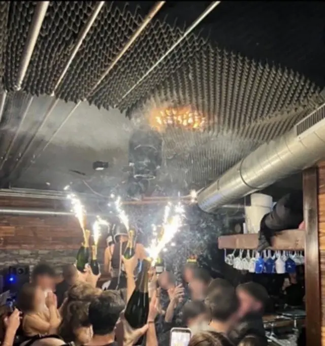 Sparklers lighting a fire on the ceiling inside the bar