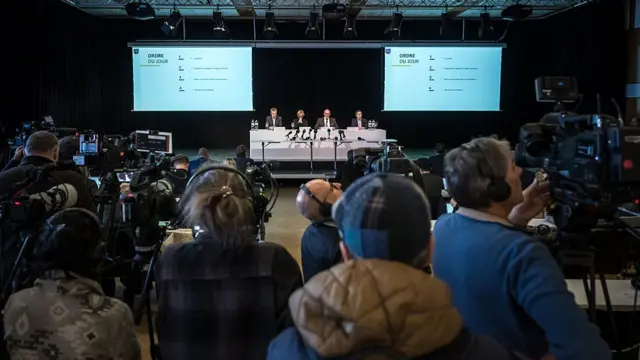 Media getting their cameras ready as the officials take their seats at the press conference.