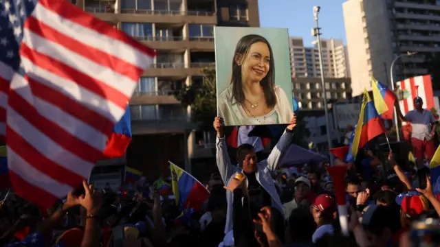 Venezuelans hold a painting of Maria Machado