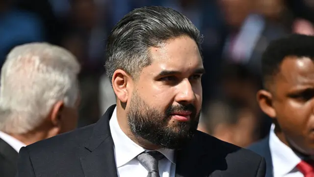Nicolás Maduro Guerra wearing a suit and tie, stood outside and looking away from the camera