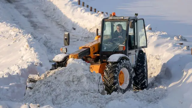 A man clears snow with a digger near Gartly, Aberdeenshire, on Tuesday morning
