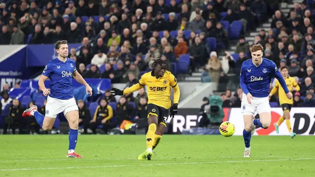 Mateus Mane of Wolves nets as two Everton players try to close him down
