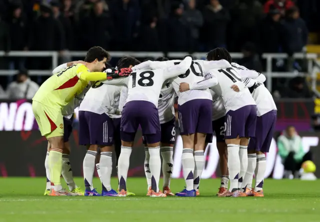 Manchester United players huddle before the match