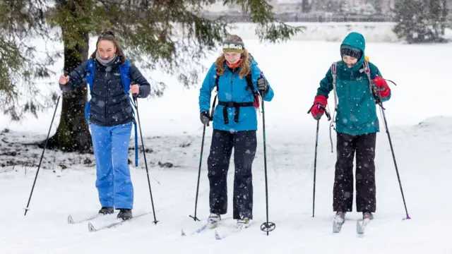 Three young women make the most to of the weather as heavy snow continues to cause disruption to many part of the Highlands.