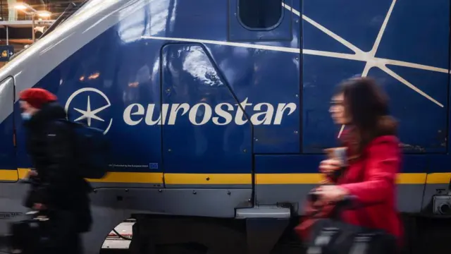 Two people walk past the front of a Eurostar train