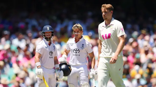 acob Bethell (middle) of England reacts after being struck by the ball during day four of the Fifth Test in the 2025/26 Ashes Series between Australia and England