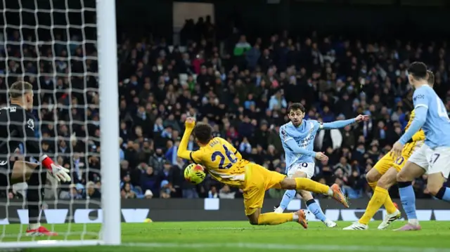 Bernardo Silva shoots as he is challenged by Brighton's Yasin Ayari