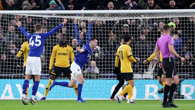 Michael Keane celebrates with his arms raised after scoring for Everton