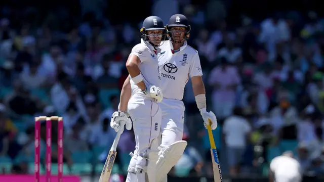 England's Jacob Bethell (L) talks with teammate Joe Root