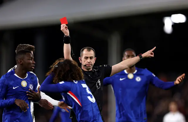 Referee Peter Bankes shows a red card