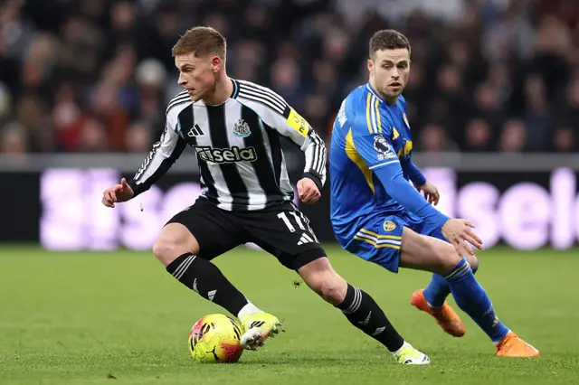 Harvey Barnes of Newcastle United is challenged by Gabriel Gudmundsson of Leeds United