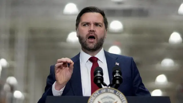 Vance speaking into mic whilst gesturing with his hand