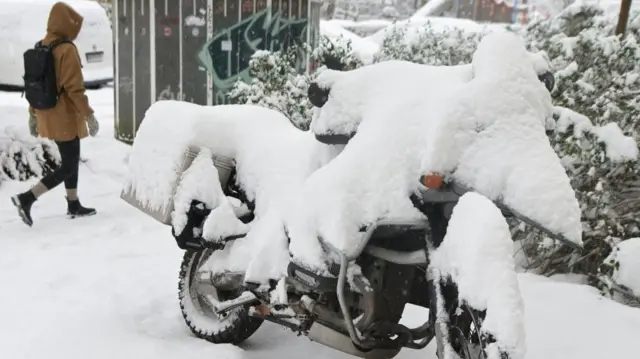 A motorbike is covered in snow, as Germany is bracing for adverse weather conditions this week, with forecasts predicting snow, storms, and freezing temperatures across large parts of the country, in Hamburg, Germany, January 8, 2026.