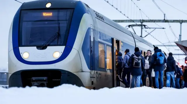 Passengers are on the platform amid snow in Breukelen, Netherlands, 08 January 2026. Due to the ongoing winter weather, the Dutch Railways (NS) have adjusted the timetable and are running fewer trains.
