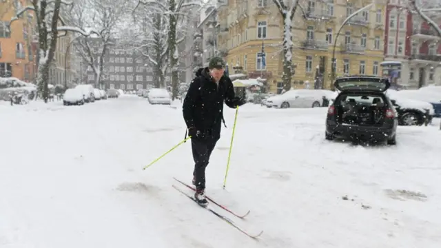 A man skiing down a road covered in snow.