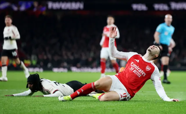 Gabriel Martinelli (R) of Arsenal goes down following a challenge by Jeremie Frimpong (L) of Liverpool