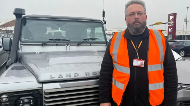 Geoff Lake wearing hi vis in front of his 4x4 volunteer vehicle