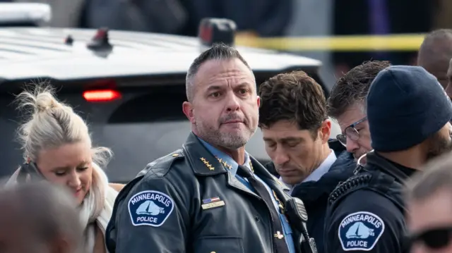 Brian O'Hara in police uniform, surrounded by other officers, after the shooting in Minnesota yesterday