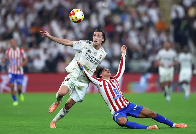 Alvaro Carreras of Real Madrid fouls Atletico's Giuliano Simeone