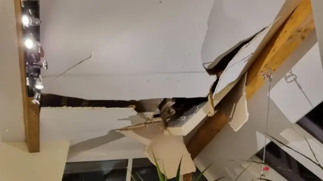 The top part of a roof is seen caved in from the inside.