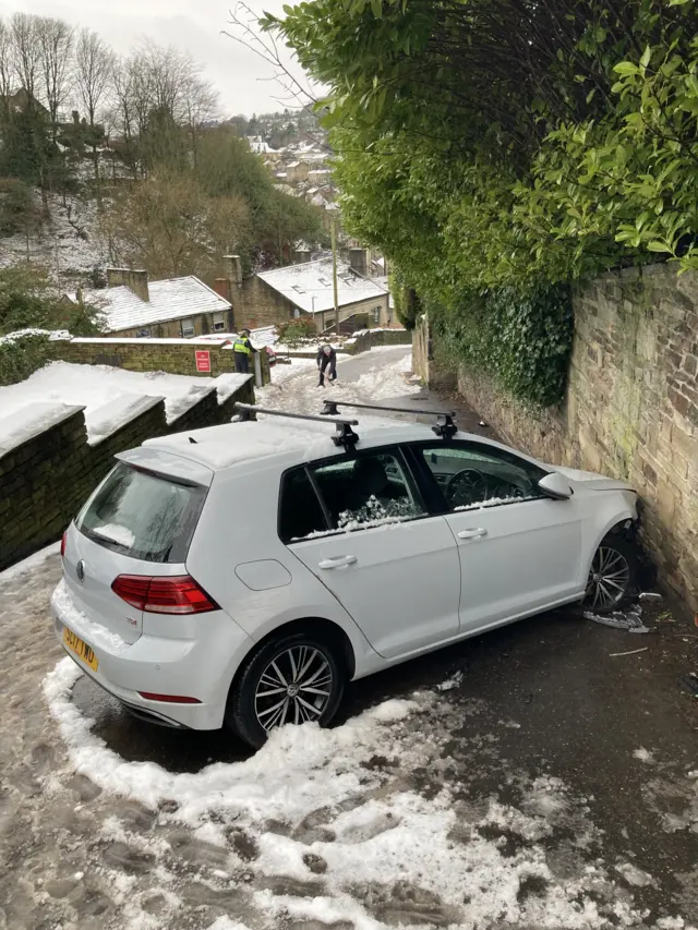 A car that has collided with a wall in snow