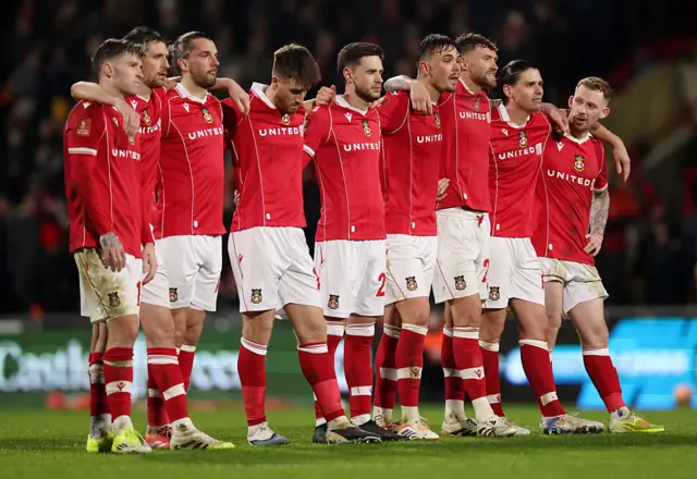 The players of Wrexham watch on during the penalty-shoot-out