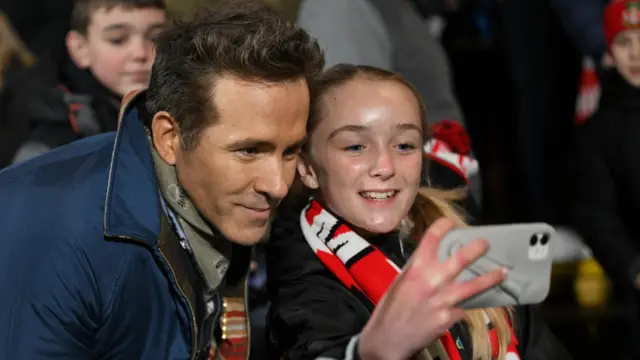 Ryan Reynolds poses for a selfie with a fan