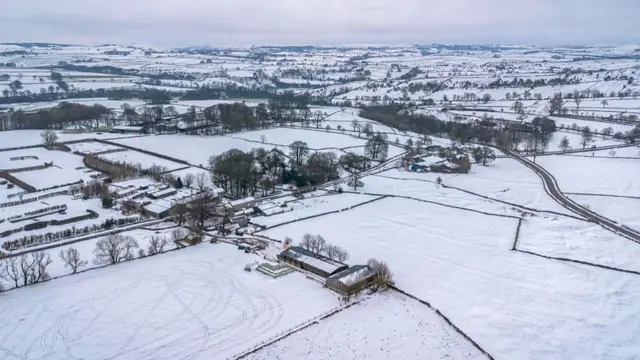 Snow is seen in a large farmer's field
