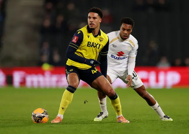 OXford and MK Dons players battle for the ball
