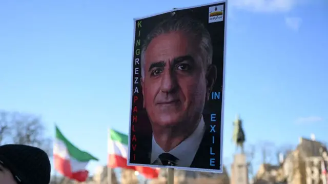 A protester holds a placard of Iranian opposition leader and son of the last Shah of Iran, Reza Pahlavi, during a demonstration against the Iranian regime's crackdown on protests in central Paris, on January 4, 2026