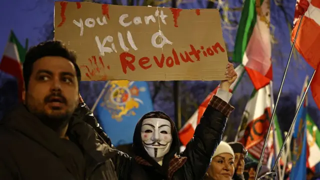 Protesters outside the Iranian embassy in London holding placards