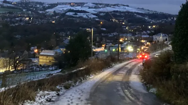 Patches of snow on hillsides and field visible in the distance from a high point
