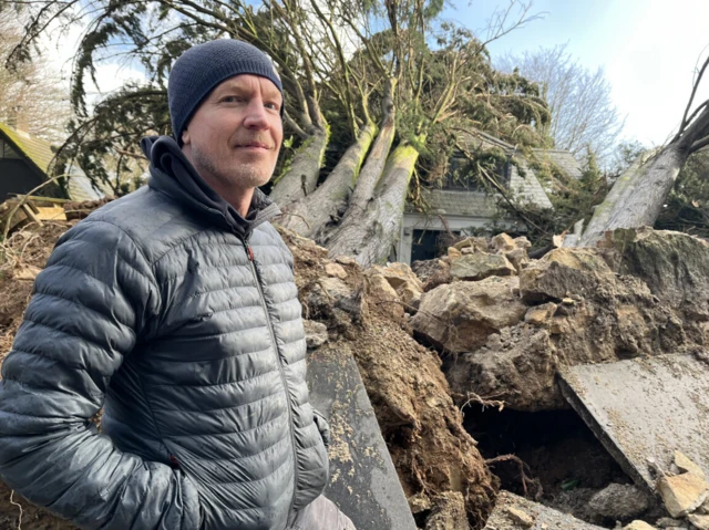 Rob stands in front of a large fallen tree
