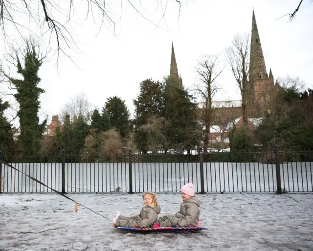 Girls being pulled on a sledge