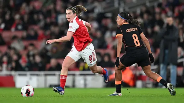 Mariona Caldentey runs with the ball whilst under pressure from Andressa