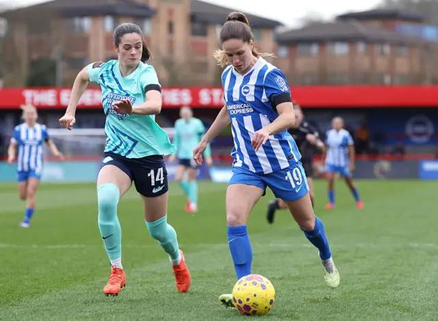 Marisa Olislagers of Brighton runs with the ball whilst under pressure from Freya Godfrey of London City Lionesses