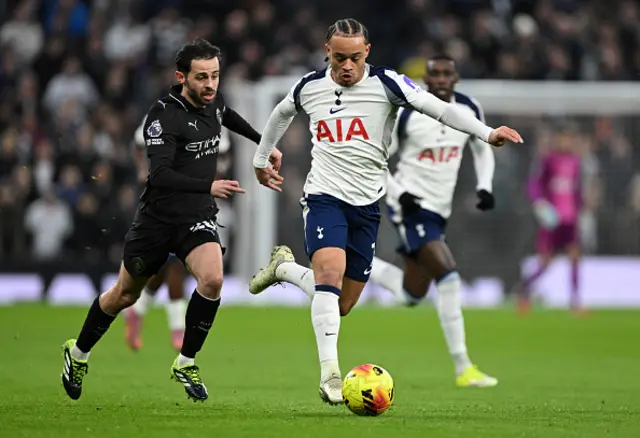 Xavi Simons of Tottenham Hotspur is challenged by Bernardo Silva