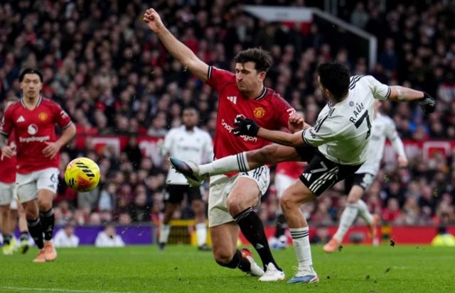Fulham's Raul Jimenez (right) is tackled by Manchester United's Harry Maguire as he tries to shoot at goal