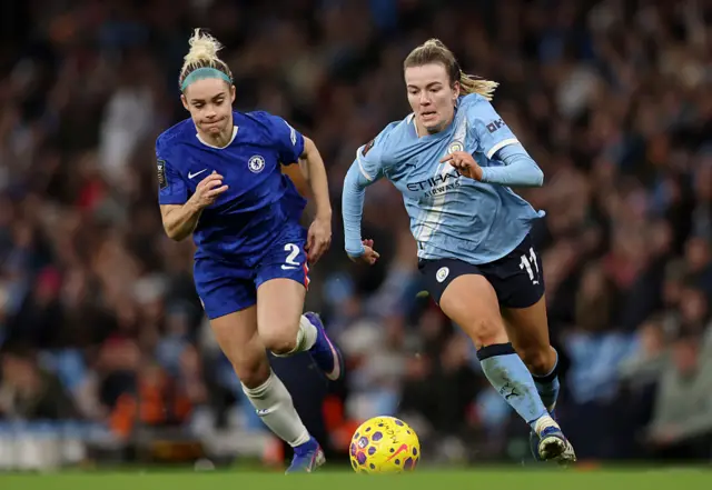 Lauren Hemp of Manchester City runs with the ball whilst under pressure from Ellie Carpenter of Chelsea